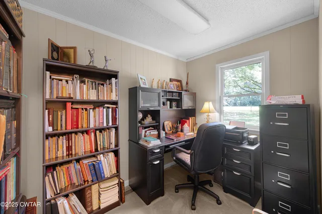 a view of a workspace with a bookshelf and a workspace