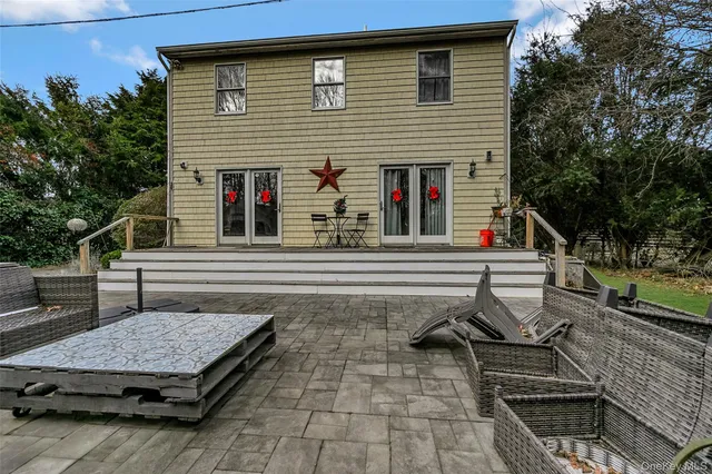 a view of a patio with table and chairs with wooden floor and fence