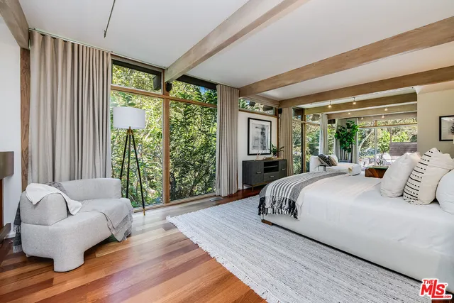 a spacious bedroom with a bed and a large window