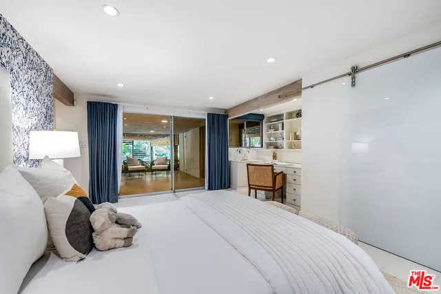 a view of a patio with table and chairs under an umbrella with wooden fence