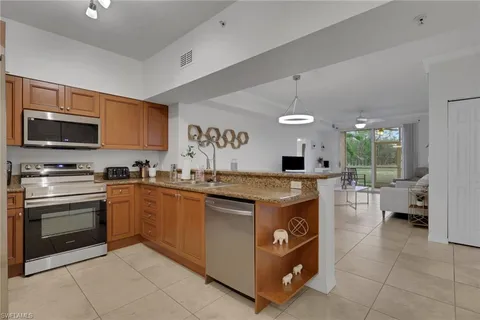 a kitchen with stainless steel appliances granite countertop a stove a sink and a microwave