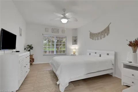 a spacious bedroom with a bed and a flat screen tv