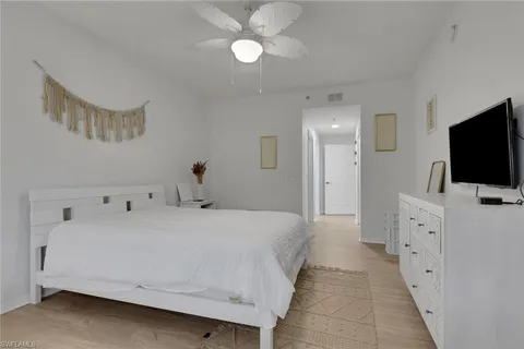 a bedroom with a bed and a flat tv screen on dresser