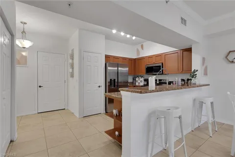 a kitchen with stainless steel appliances granite countertop a refrigerator and a stove top oven