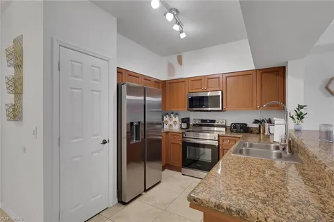 a kitchen with stainless steel appliances granite countertop a refrigerator a stove top oven a sink and dishwasher