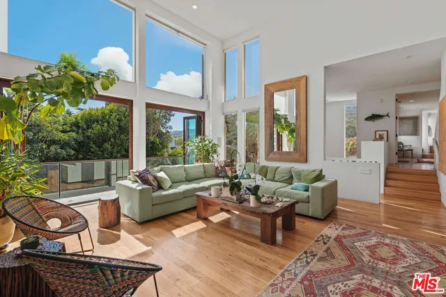 a living room with furniture and a view of kitchen