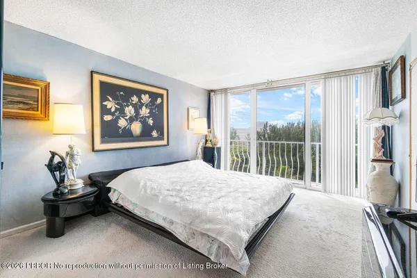 a bedroom with a bed and a view of balcony