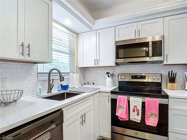 a kitchen with refrigerator a sink and cabinets