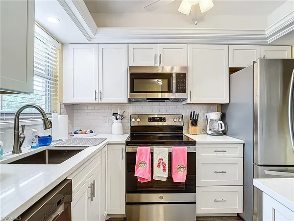 a kitchen with stainless steel appliances granite countertop a sink stove and microwave