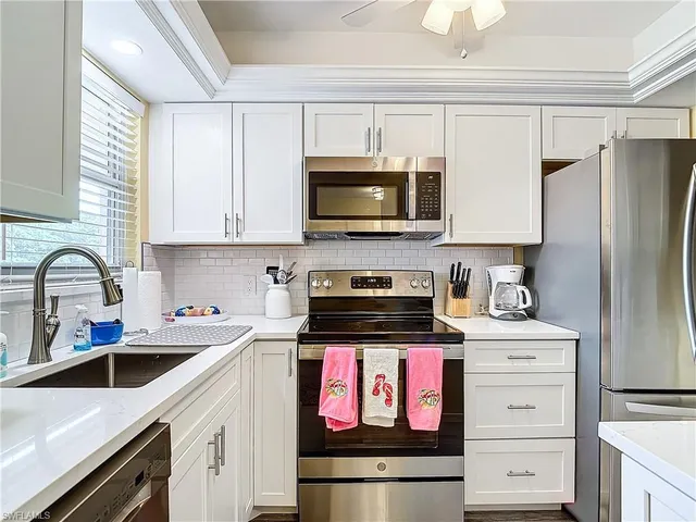 a kitchen with stainless steel appliances granite countertop a sink stove and microwave