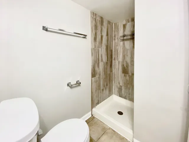 a bathroom with a shower a toilet and a sink