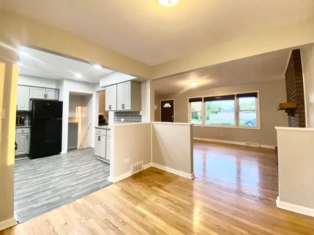 a view of a kitchen with kitchen island wooden floor center island and stainless steel appliances