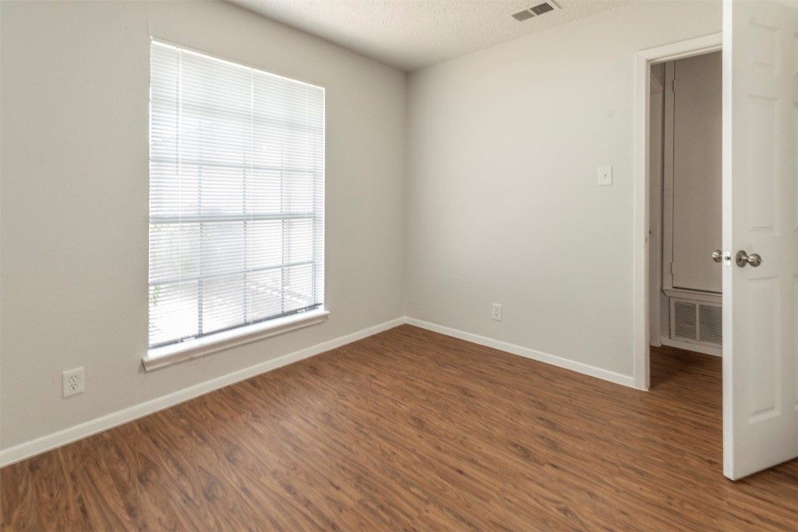 2300 Misty Morning Way, Unit A Round Rock, TX 78664 - Photo 11 of 16 an empty room with wooden floor and windows