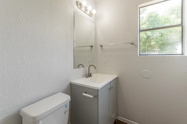 a bathroom with a toilet sink and mirror