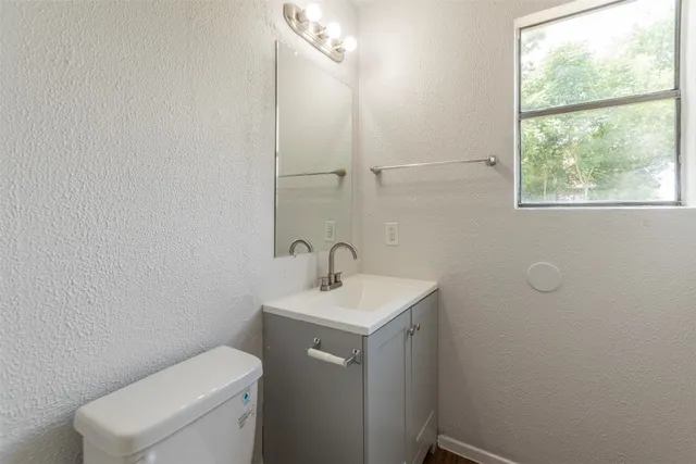 a bathroom with a toilet sink and mirror