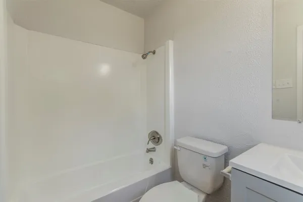 a white toilet sitting next to a bath tub