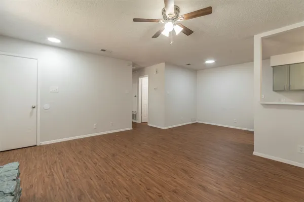an empty room with wooden floor and ceiling fan