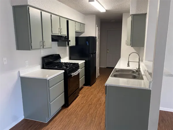 a kitchen with a sink stove and refrigerator