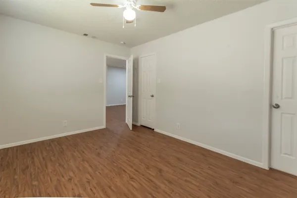 a view of an empty room with wooden floor