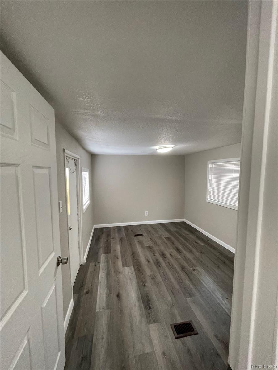 275 Junction Loop Road Empire, CO 80438 - Photo 2 of 18 an empty room with wooden floor and windows
