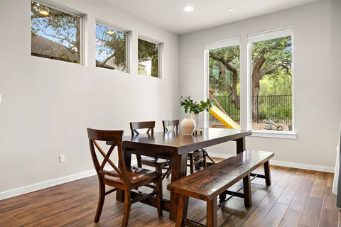 a view of a dining room with furniture a potted plant and wooden floor