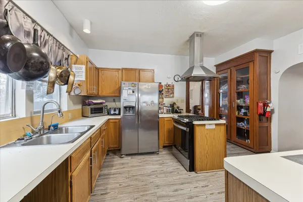 a kitchen with stainless steel appliances granite countertop a sink a stove and a refrigerator