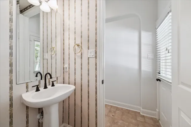a spacious bedroom with a bed a fireplace and a chandelier