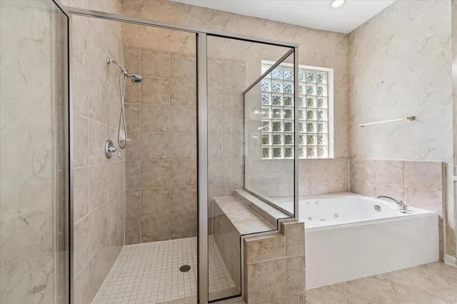 a spacious bathroom with a tub sink and mirror