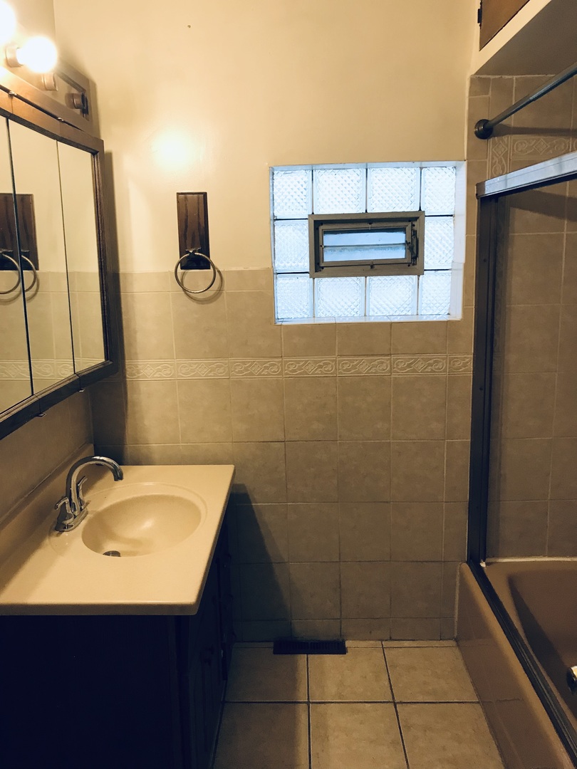 3246 West 65th Street Chicago, IL 60629 - Photo 19 of 50 a bathroom with a sink a toilet and mirror