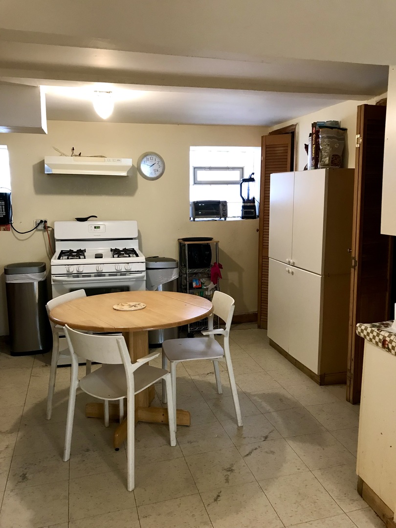 3246 West 65th Street Chicago, IL 60629 - Photo 33 of 50 a kitchen with a table chairs refrigerator and a stove
