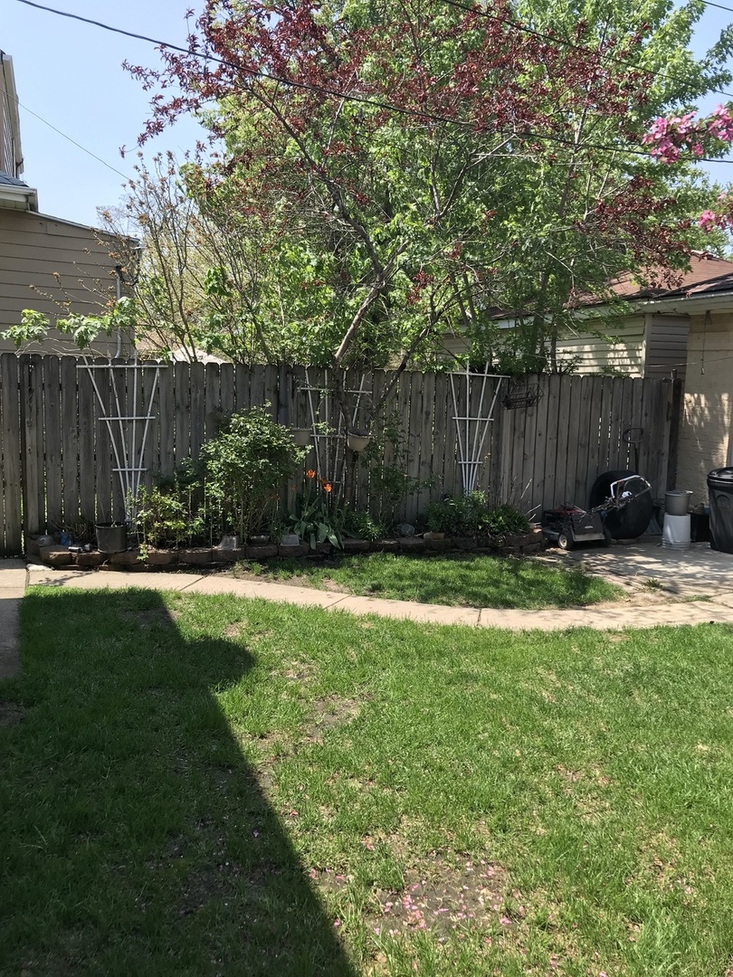 3246 West 65th Street Chicago, IL 60629 - Photo 46 of 50 a view of backyard with potted plants and wooden fence
