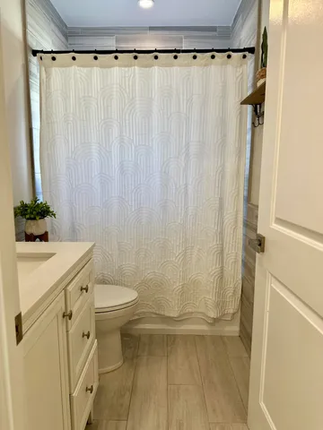 a view of a wooden house with a big yard and potted plants