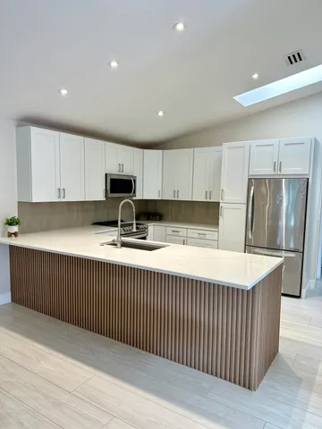 a kitchen with stainless steel appliances a refrigerator sink and cabinets