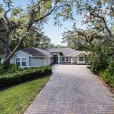 a front view of a house with a yard and trees