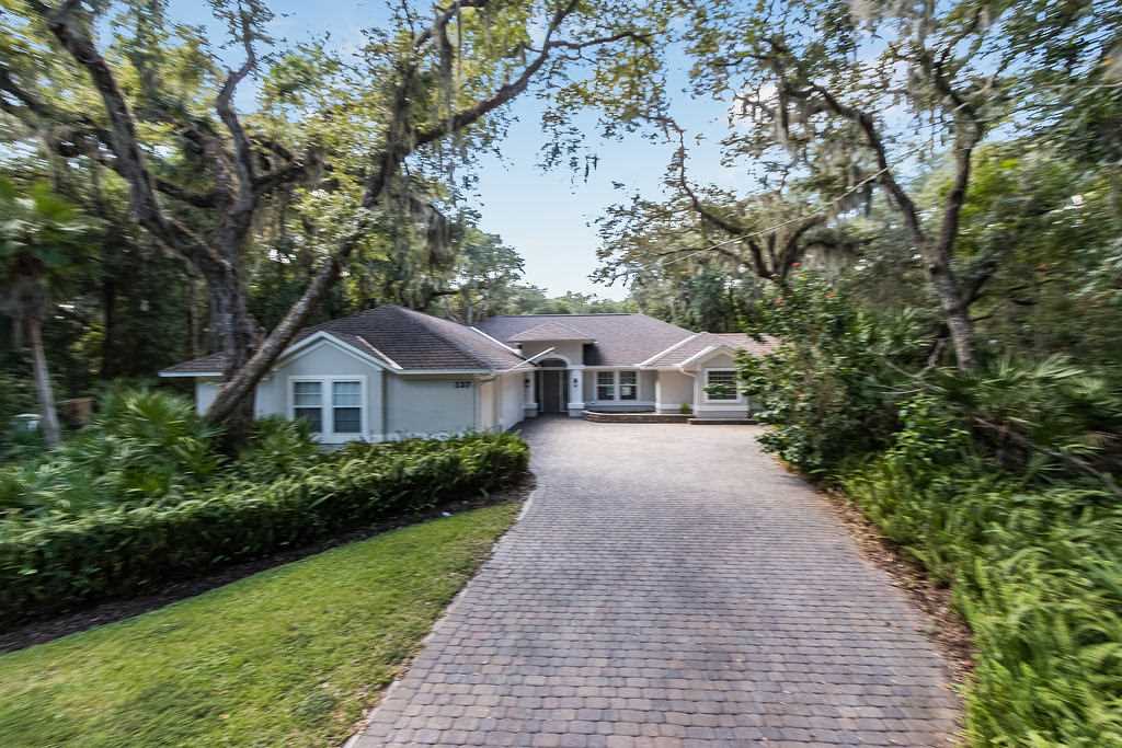 137 Island Hammock Way St. Augustine, FL 32080 - Photo 1 of 38 a front view of a house with a yard and trees