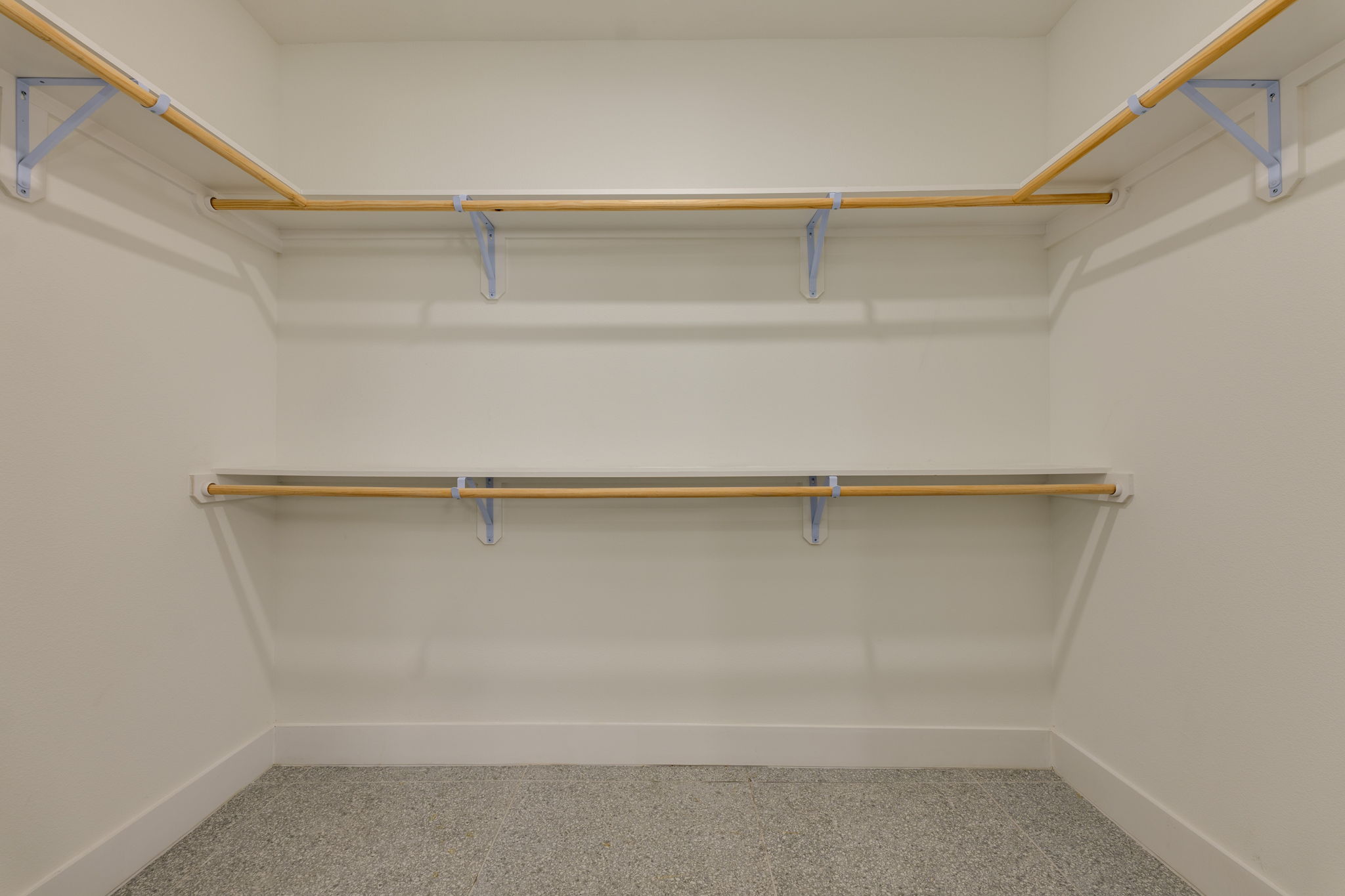 1701 Simond Avenue, Unit 618 Austin, TX 78723 - Photo 12 of 38 This closet features white walls, light-colored wooden hanging rods, and a speckled grey floor