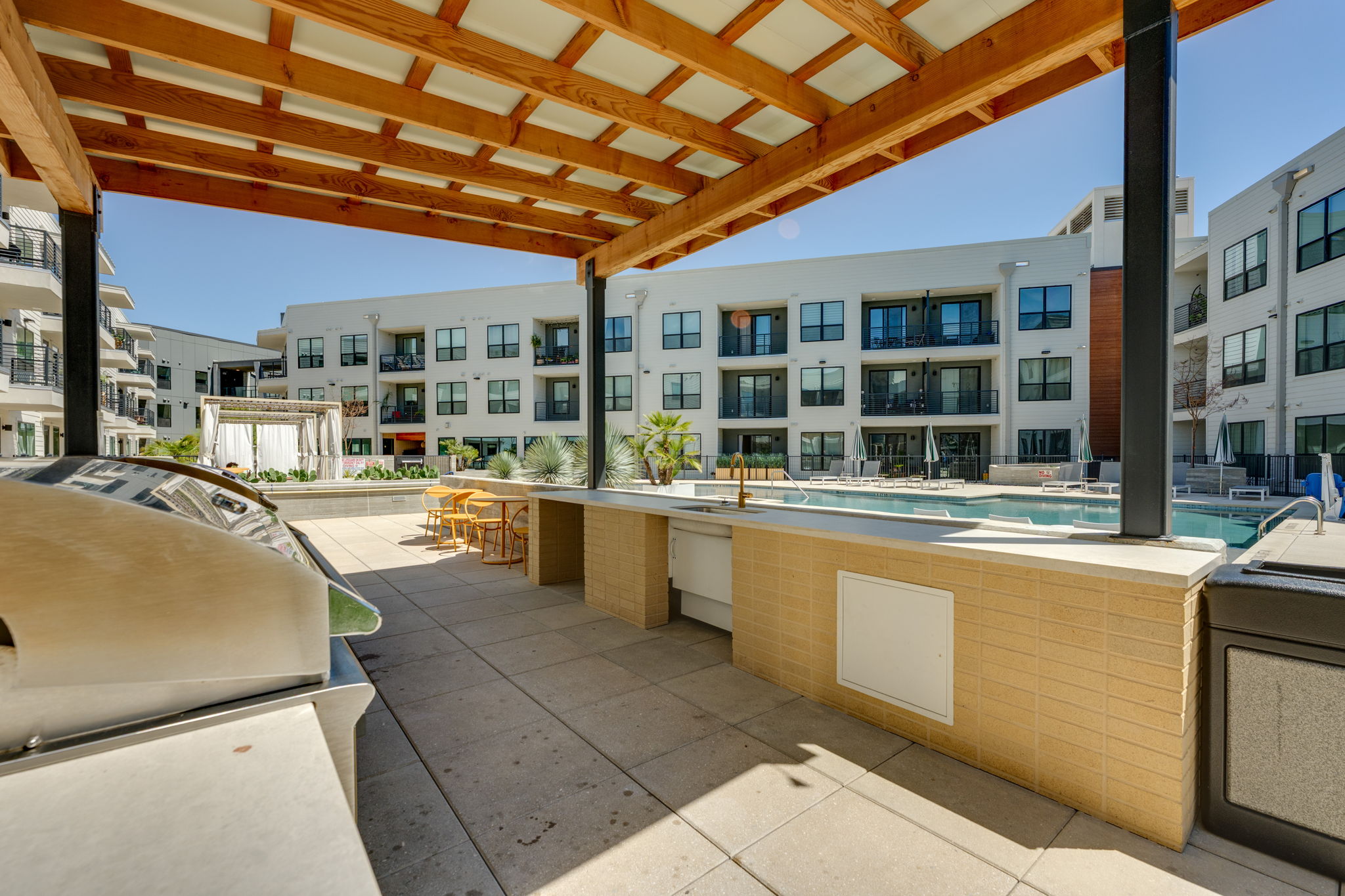 1701 Simond Avenue, Unit 618 Austin, TX 78723 - Photo 15 of 38 Outdoor living area featuring a covered patio, a built-in BBQ grill, and a swimming pool