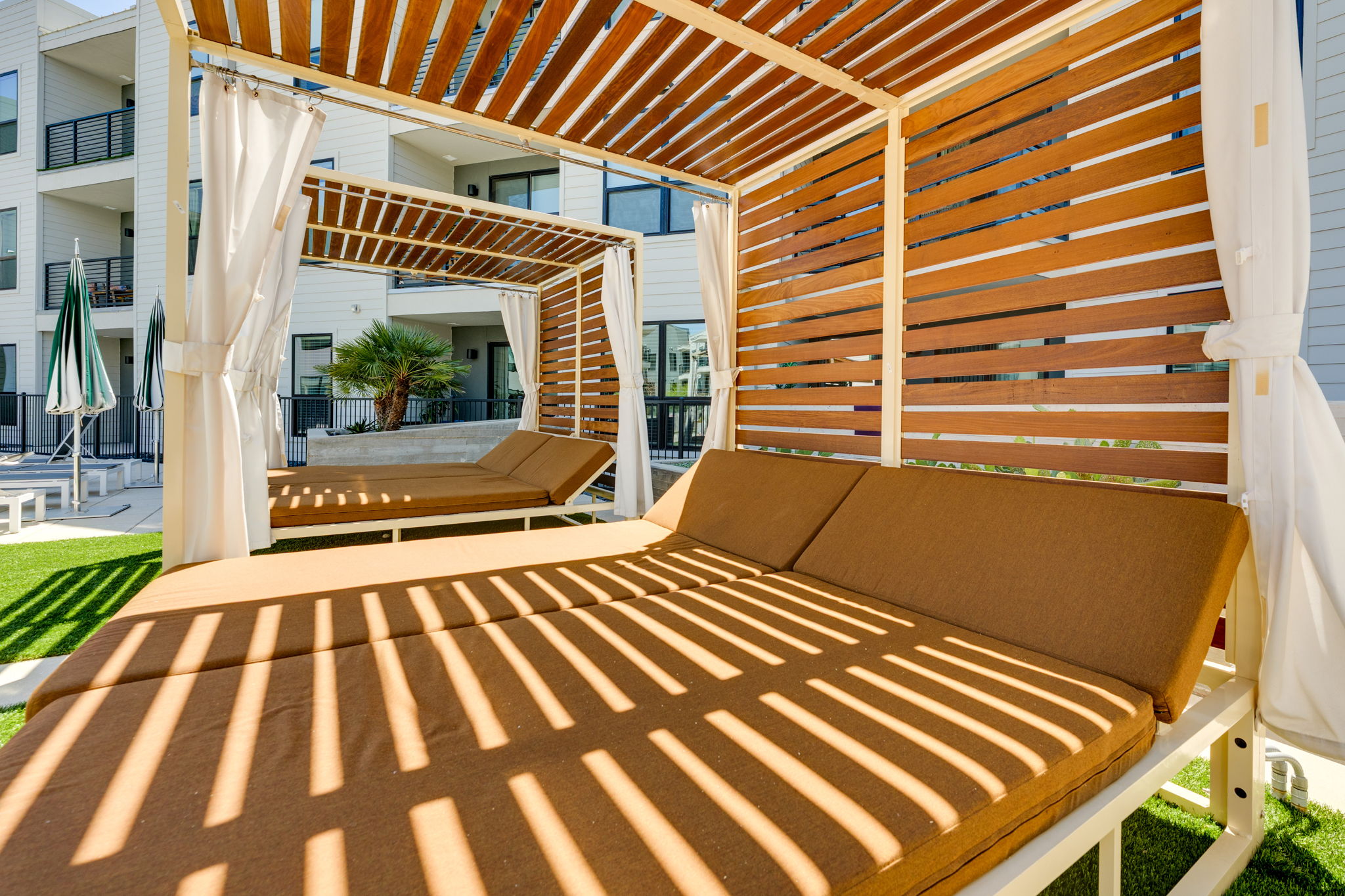 1701 Simond Avenue, Unit 618 Austin, TX 78723 - Photo 16 of 38 Outdoor cabana with slatted wooden roof and privacy screens, featuring a cushioned chaise lounge