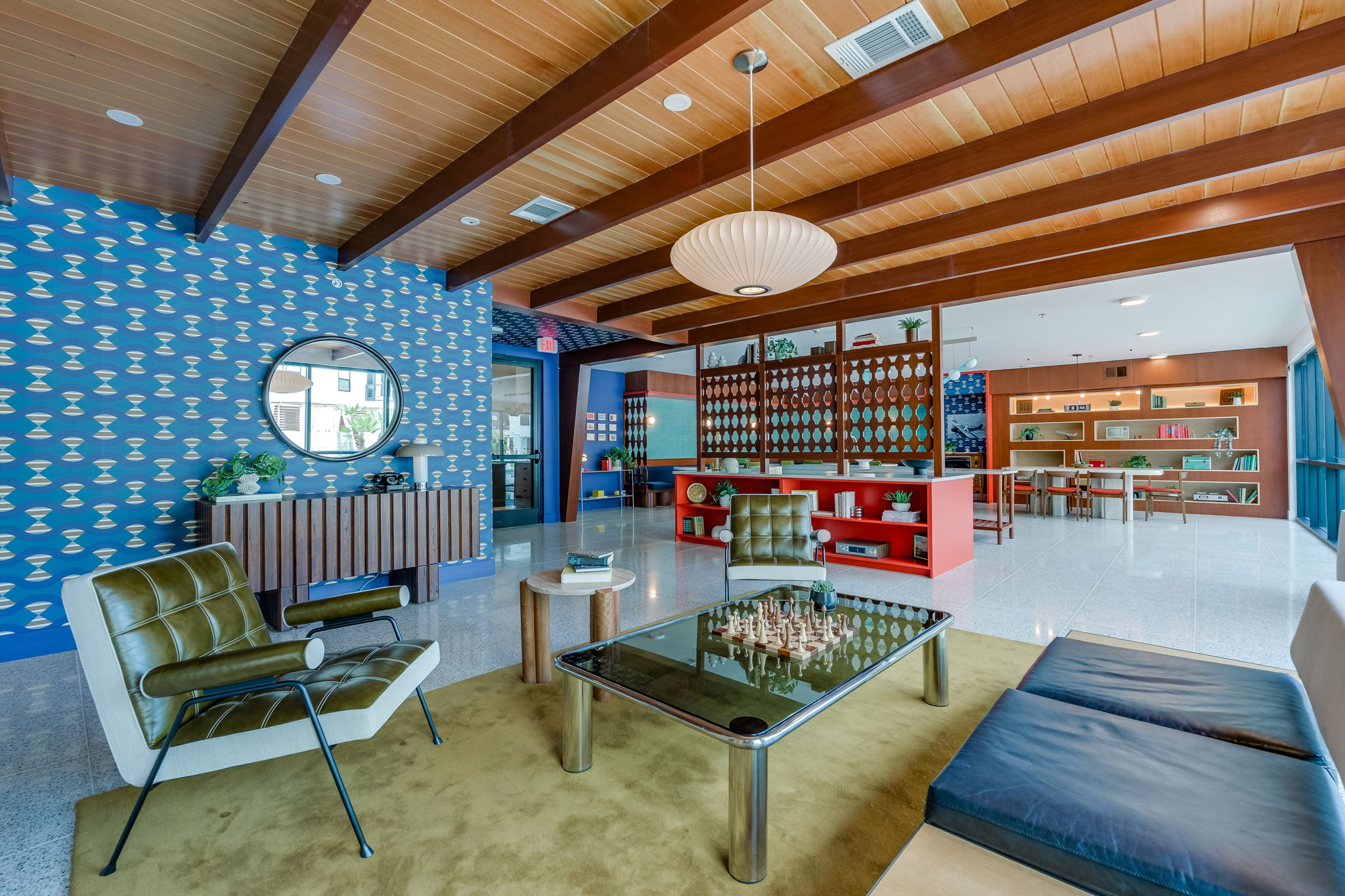 1701 Simond Avenue, Unit 618 Austin, TX 78723 - Photo 18 of 38 The property features an inviting common area with a distinctive wood-beamed ceiling, stylish patterned wallpaper, and polished flooring