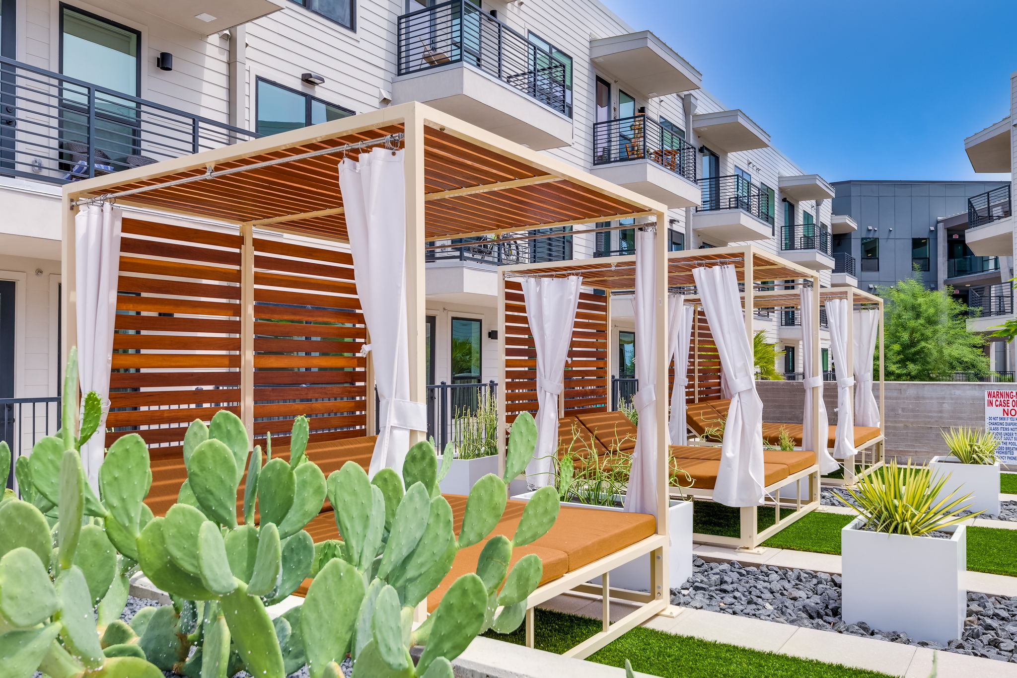 1701 Simond Avenue, Unit 618 Austin, TX 78723 - Photo 20 of 38 The property features outdoor cabanas with slatted wood details and white privacy curtains