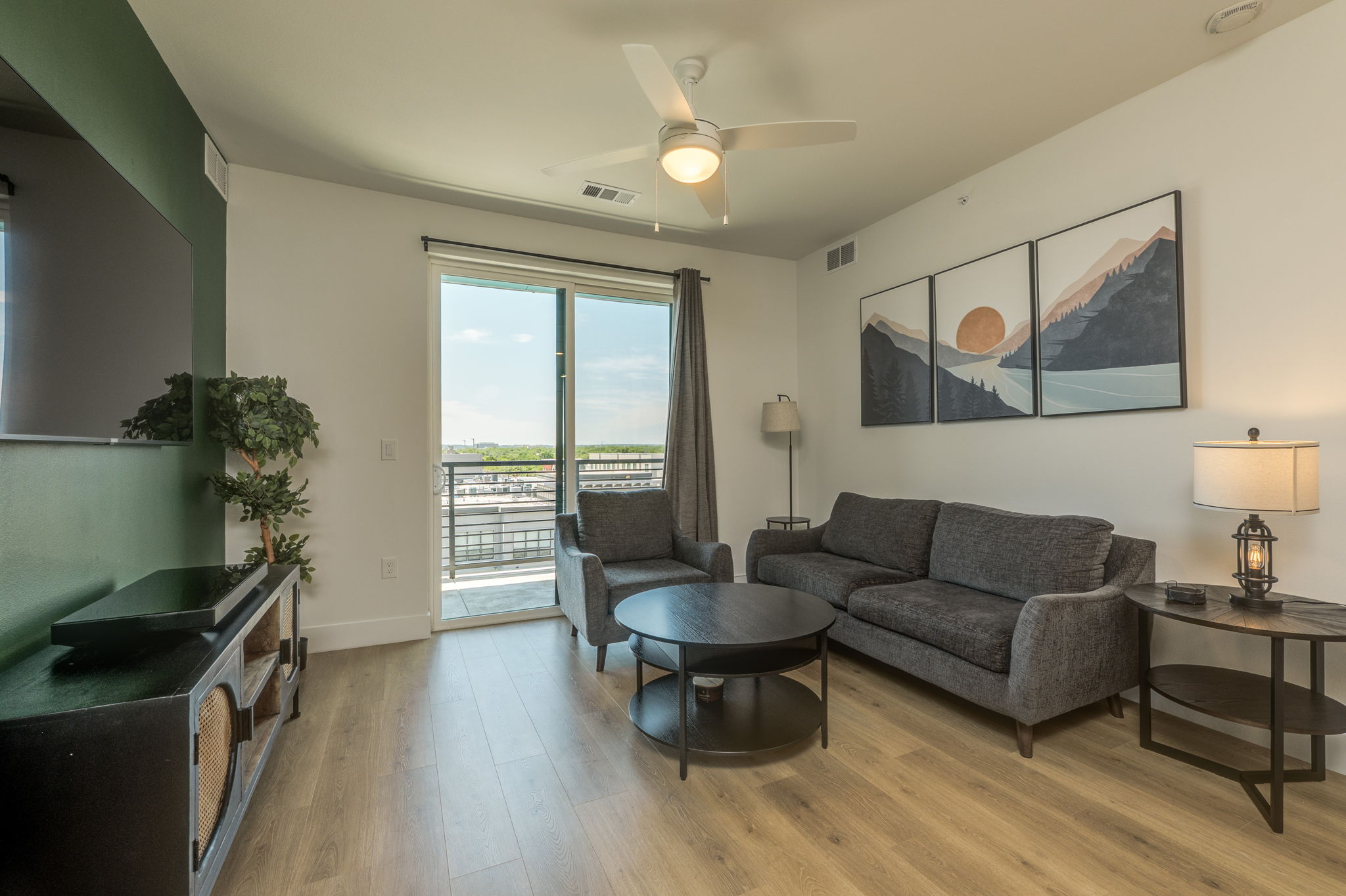 1701 Simond Avenue, Unit 618 Austin, TX 78723 - Photo 5 of 38 The living space features light wood-look flooring, a ceiling fan, and sliding glass doors leading to an outdoor area
