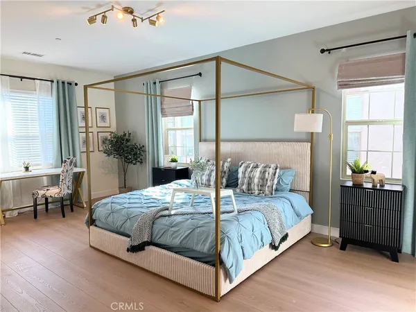 a bedroom with a large bed and a chandelier