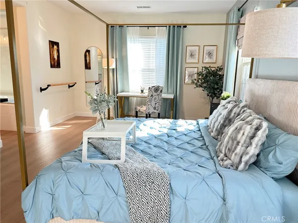 a bedroom with a large bed and a potted plant