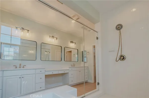 a spacious bathroom with double vanity and a mirror