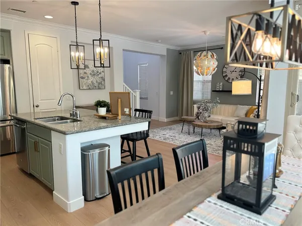 a kitchen with kitchen island granite countertop a sink a stove and a dining table