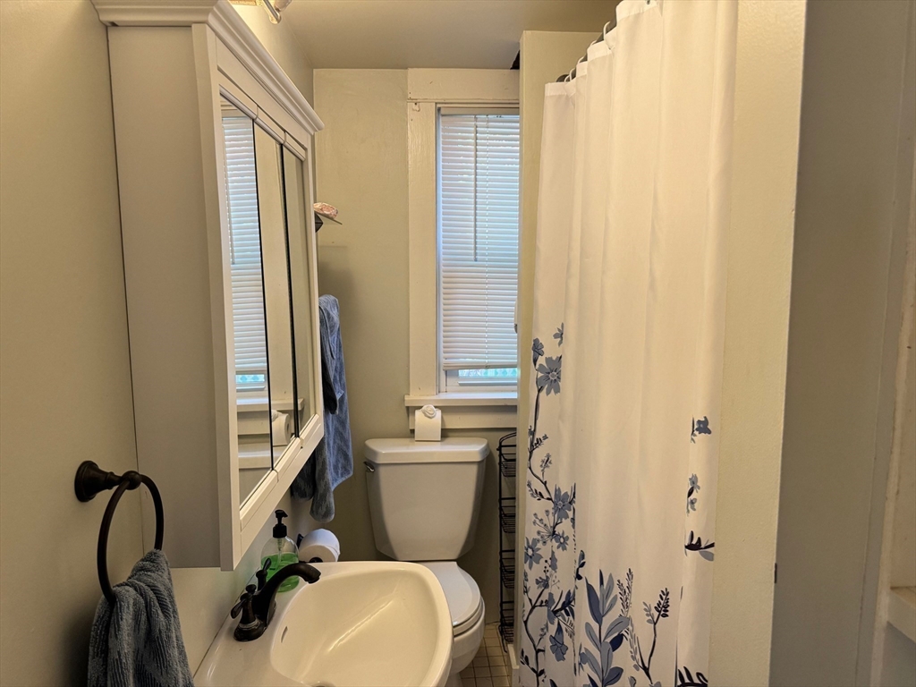 14 Field Street Seekonk, MA 02771 - Photo 11 of 26 a bathroom with a sink a toilet and shower curtain