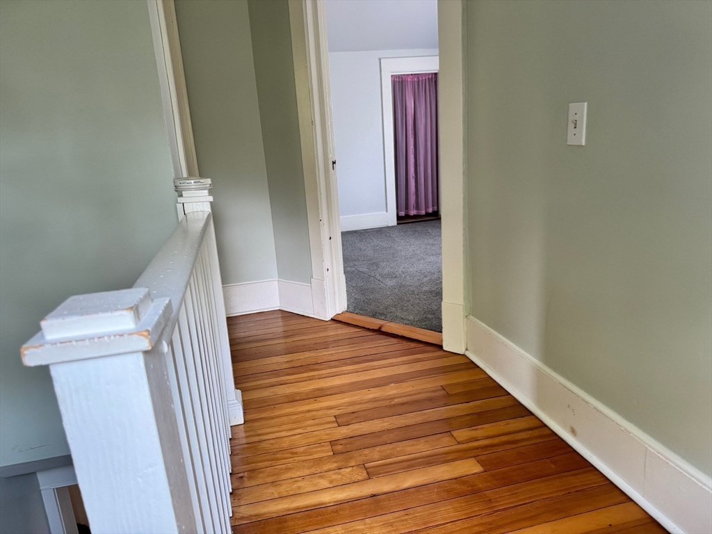 14 Field Street Seekonk, MA 02771 - Photo 15 of 26 a view of a hallway with wooden floor and staircase