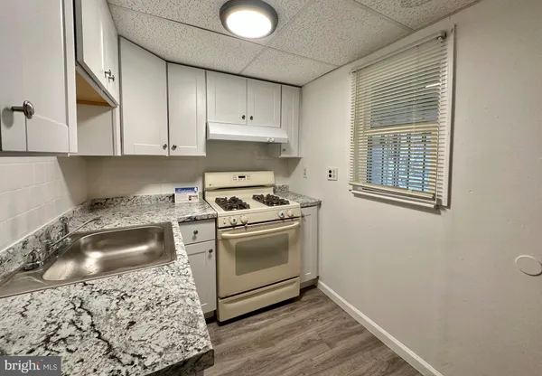 a kitchen with granite countertop a sink and a stove top oven