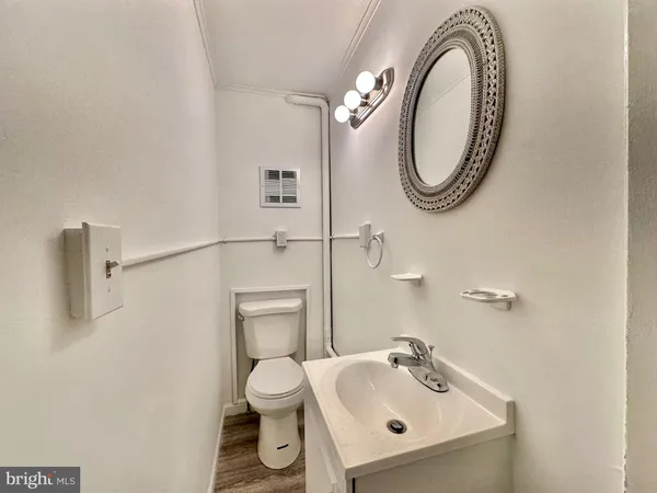 a bathroom with a sink mirror and toilet