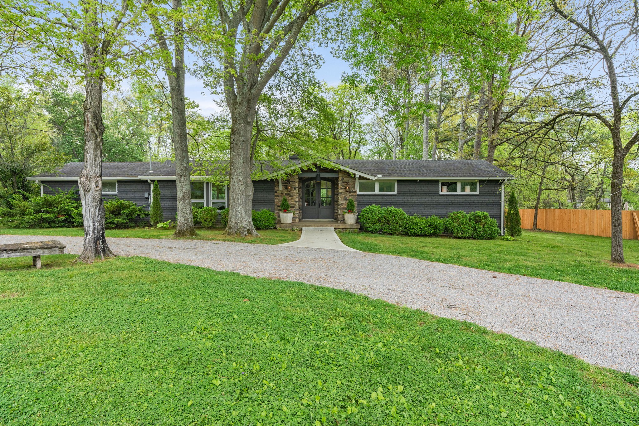 a front view of a house with a yard and trees